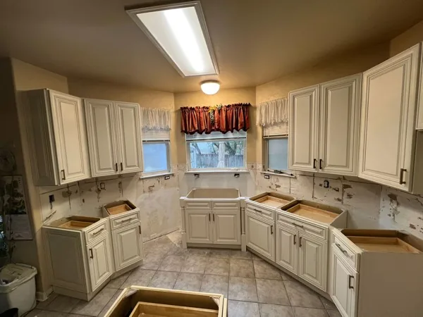 New kitchen cabinets set on an existing tile floor before the countertops go in