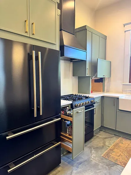 sage green kitchen with black refrigerator and gas range by WoodArt Cabinets San Antonio