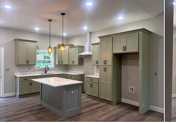 sage green kitchen with island and natural light by WoodArt Cabinets San Antonio