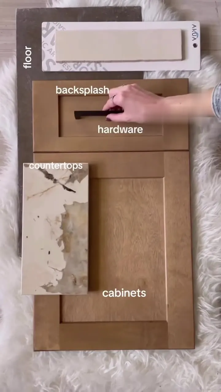 Flooring, backsplash, hardware, countertop and cabinet door samples laid out together